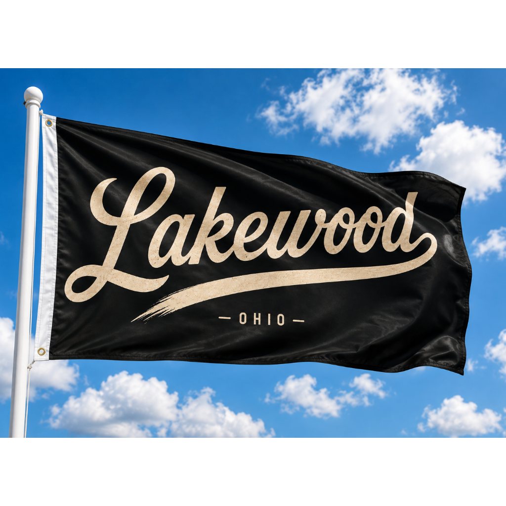 A black flag with 'Lakewood - Ohio' printed in beige script and serif lettering, flying on a white flagpole against a bright blue sky with white clouds.