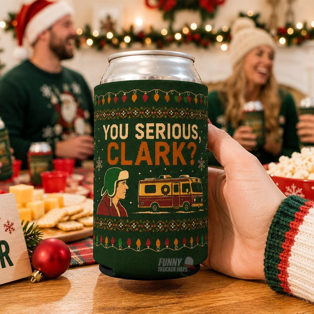 A hand holds a green can cooler featuring a Christmas-themed graphic that reads 'YOU SERIOUS, CLARK?' with a camper illustration. The background shows a festive holiday gathering with people in sweaters and Santa hats, holding matching can coolers.