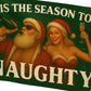 Flag with a design of a pirate and a woman in a Santa hat, with text 'Tis the season to be naughty' on a green background.